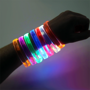 Close up on arm wearing 7 different colored LED wristbands
