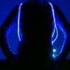 Someone wearing LED drawstring bag from front so straps are shining bright blue neon