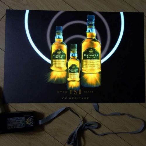 Three bottles of different sizes lighting up on black EL poster with plug inverter