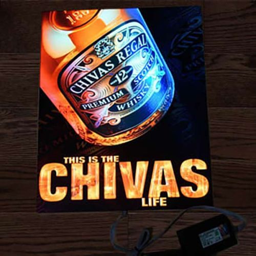 Picture of EL advertisement poster with Chivas logo and bottle illuminating brightly on wooden floor