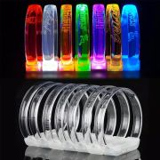 seven different style fonts and logos laser engraved onto LED bracelets, top half of photo showing the bracelets on and lighting up different colors, bottom half showing the same bracelets off and are clear