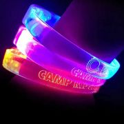 Three custom LED bracelets on wrist each lighting up a different neon color: orange, pink and blue