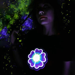 Girl in dark room with starry background wearing a custom flower light up shirt design