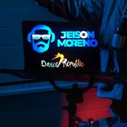 Custom DJ logo with name and design lighting up brightly on back of laptop
