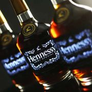 Hennessy light up labels on three bottle of Hennessy lighting up fully, only center bottle is in focus