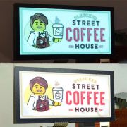 Coffee house logo with male barista split in two, top half shown lighting up fully in dark background, bottom photo showing design with lights on not lighting up