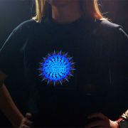 Close up of woman with two hands on hips showing customized LED shirt design with Frendly Gathering logo lighting up brightly on chest