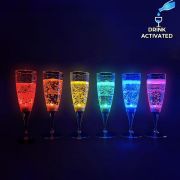 Line up of 6 drink activated LED champagne flutes each lighting up a different rainbow color: red, orange, yellow, green, blue and purple
