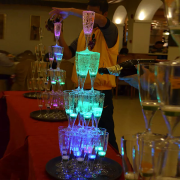 LED champagne glasses stacked into a tower glowing bright neon blue and green