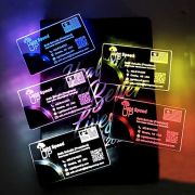 Five LED business cards lighting up different colors on black background where laser engraved logo is illuminating bright colors