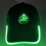 Black baseball hat with bright glowing green LED brim and neon night logo illuminating green