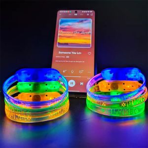 two stacks of LED bracelets next to phone playing music with sound activated lights