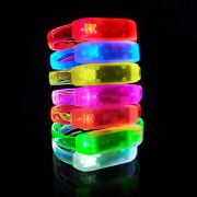 All 7 color LED bracelets stacked in a row shining bright red, blue, yellow, pink, orange, green and white