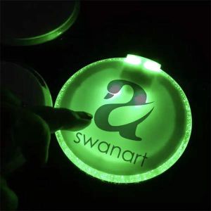 LED coaster that is glowing lime green with a company logo for SwanArt