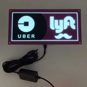 Uber and Lyft logos illuminating on EL poster for car