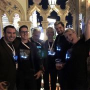 Group photo of 6 people in Venetian building wearing matching custom light up t-shirts illuminating on their chests