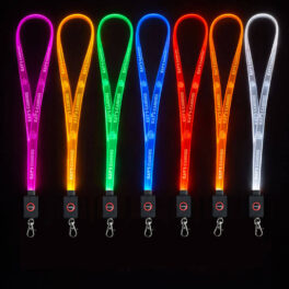 Row of brightly illuminated LED lanyards in multiple colors arranged against a black background