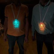 Two men wearing glowing light up LED ID badges for a Party Animal themed cruise