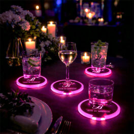 Glowing pink light up drink coasters featuring a custom logo arranged on a decorated dinner table at an evening event