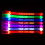 Laser-engraved LED bracelets displaying ‘Your Logo Here’ in assorted glowing colors for events and promotions