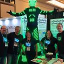Group of five people wearing custom LED shirts standing with man in full LED Tron suit