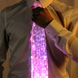 man adjusting top of neck tie that is made of led fiber optic and is shining bright pink