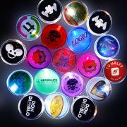 About 20 different LED pin designs in a dark room all lighting up with customized logos and artwork