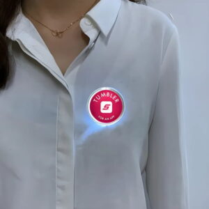 A person wearing a flashing LED button pin