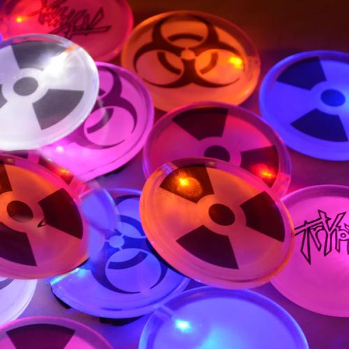 Close up of nuclear design LED pins lighting up pink, orange, blue, red and white
