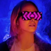 Girl wearing big LED sunglasses with cool geometric LED pattern lighting up hot pink