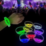 Close up of wrist wearing customized led bracelet in front of crowd waving light up wristbands