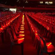 Large venue with red colored led bright batons in the seats