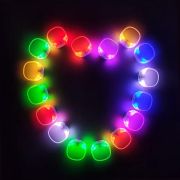 Aerial shot of silicone led bracelets lined up in the shape of a heart lighting up a different array of glowing colors