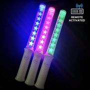 Three remote controlled LED wands with stars laser engraved, each lighting up a different LED color: blue, pink and green in a dark space