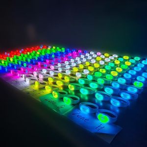 Synchronized LED DMX bracelets lighting up different colors in rows