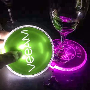 Someone holding custom LED coaster with glass on different LED coaster design in background