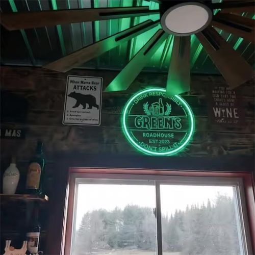 Green's Roadhouse custom engraved LED neon sign glowing green in cowboy bar