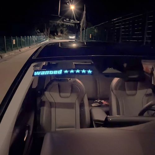 illuminating car sticker on front windshield with the words "Wanted" and five stars glowing brightly
