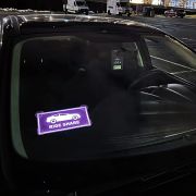 ride share glowing logo el car sticker lighting up on front windshield of car
