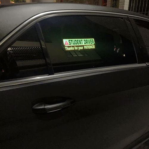 student driver safety light up sticker on window of car