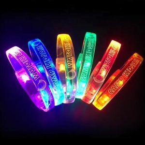 six laser engraved LED bracelets with "Camp Kid Jam" and logo all glowing a different LED color in a rainbow