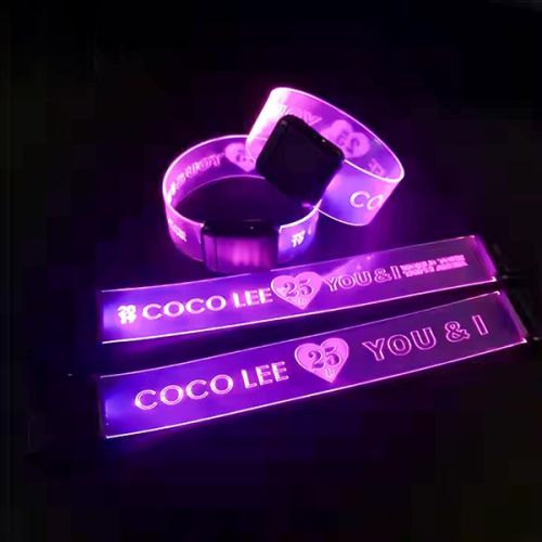 Four light up wristbands, two clasped and two open, all illuminating bright pink with the same laser engraved design