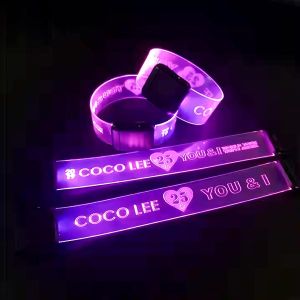 Four light up wristbands, two clasped and two open, all illuminating bright pink with the same laser engraved design