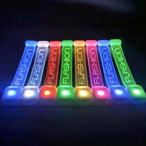 8 LED Wristbands open fully so you can see "Flashion" screen printed on each one, illuminating a different neon color from left to right: blue, white, red, green, yellow pink, dark blue, lime green