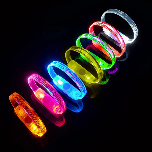 all 8 LED bracelet color options lined up on table with custom engraved messages