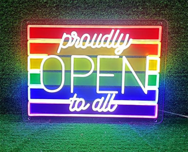 rainbow flag LED neon sign with text "proudly open to all" brightly glowing