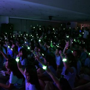 Crowd at event waving green LED bracelets in air