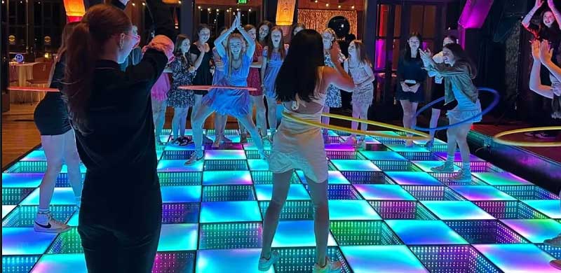 People dancing on a light up dance floor with LED tiles
