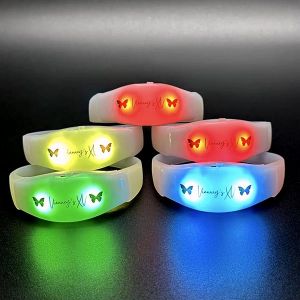 Five stacked LED bracelets with custom quincenera logo lighting up in red, yellow, green, and blue lights