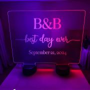 Illuminated centerpiece sign "B & B Best Day Ever" displayed on a table, with large acrylic design and dual LED bases for events.